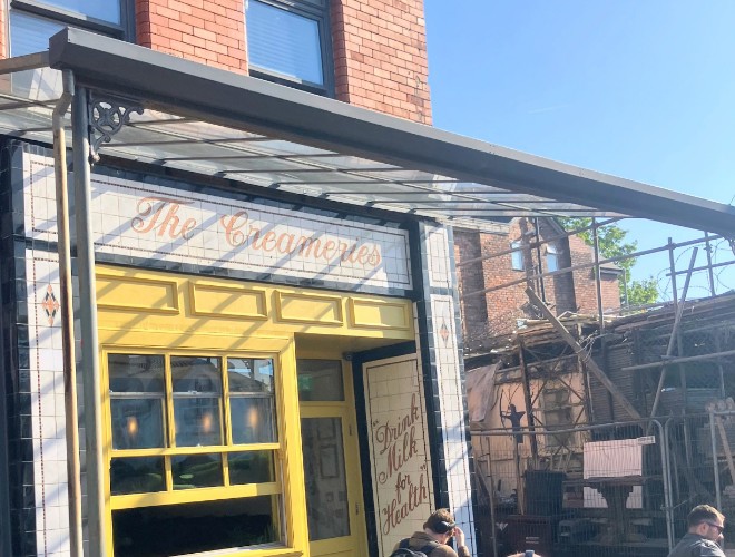 The sunny yellow exterior of The Creameries with its outdoor terrace