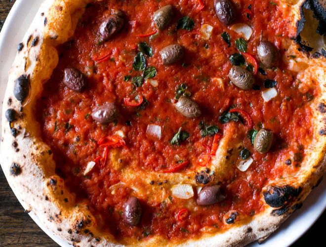 Fresh tomato and olives on a Neapolitan-style pizza at Tre Ciccio - an Italian restaurant in Altrincham