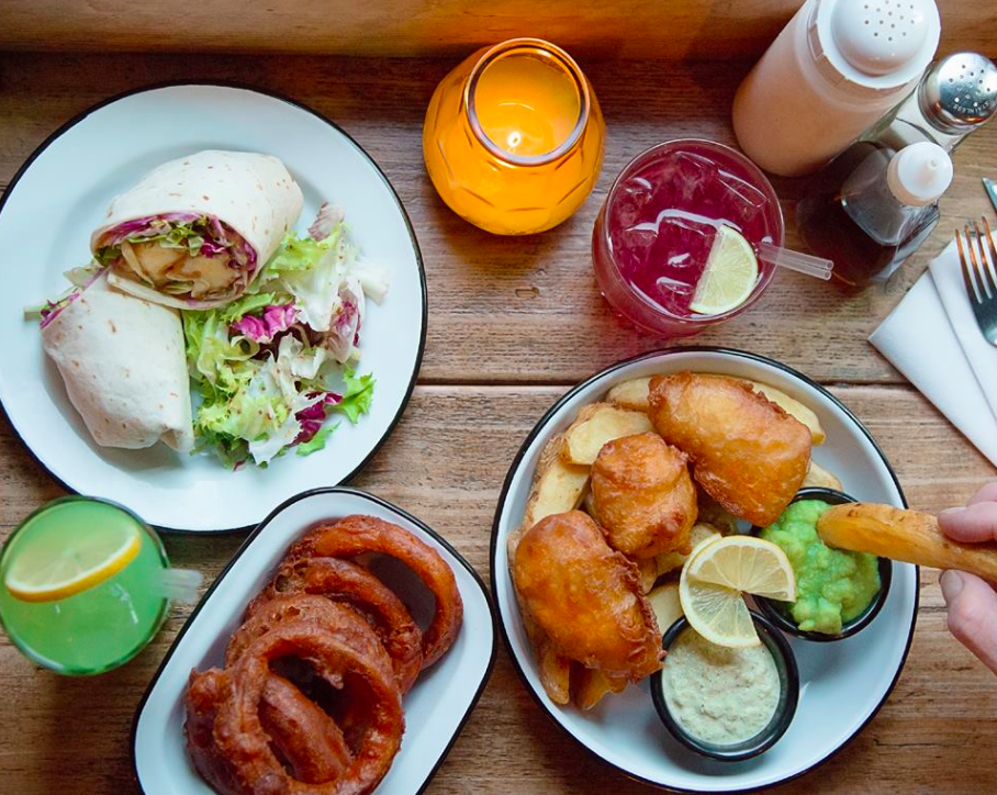 A table laded with drinks and food at Hip Hop Chip Shop in Manchester's Ancoats