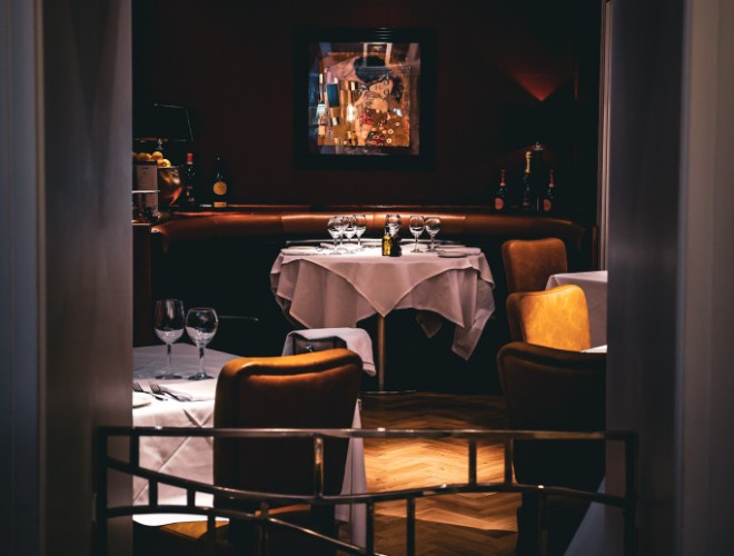 Elegant dining room at San Carlo Fiorentina with white linen tablecloths and leather chairs