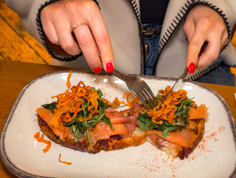 Bruschetta topped with smoked salmon, rocket, and shredded carrots