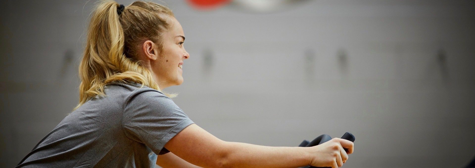 Girl cycling in gym at The Y Club - a health club with gym and classes in Castlefield, Manchester city centre