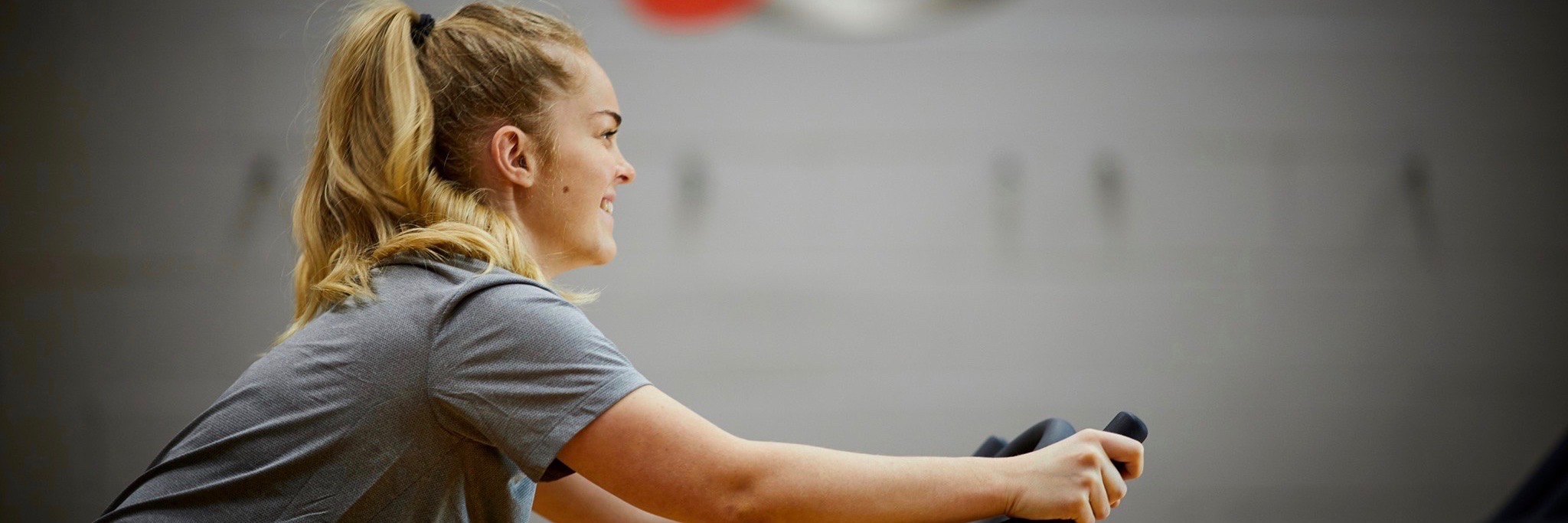 Girl cycling in gym at The Y Club - a health club with gym and classes in Castlefield, Manchester city centre