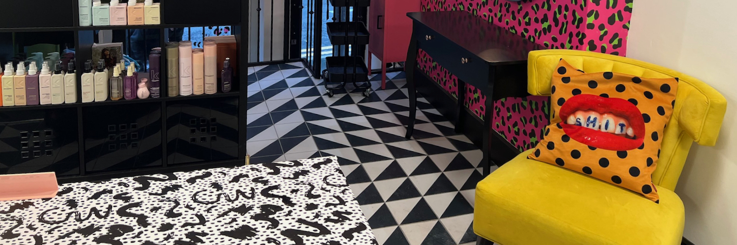 The black and white tiled floor and bright pink and yellow decor of Hex Hairdressing, a popular hair salon in Manchester city centre.