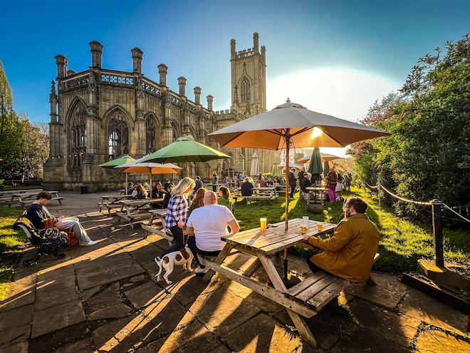 People enjoying the sunshine in the Bombed Out Church beer garden in Liverpool.
