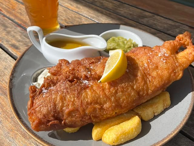 Fish, chips, peas and a pint of lager at Rain Bar in Manchester.