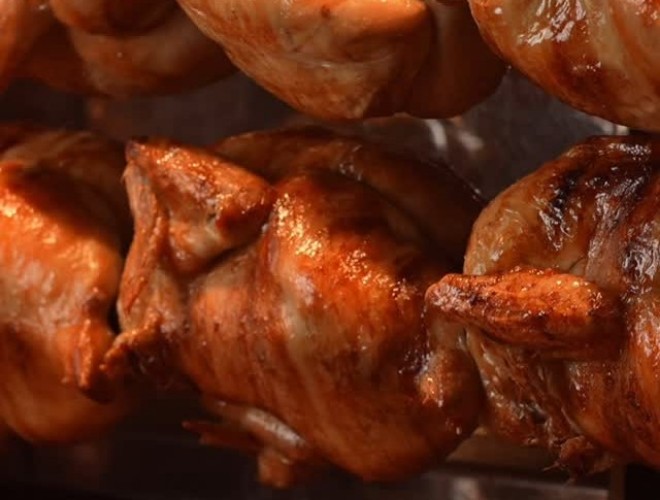 Bronzed rotisserie chickens spit-roasting at The Trading Route