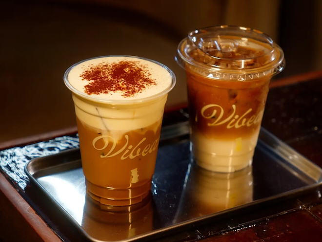 Two takeaway cups of iced Vietnamese coffee on a tray at Vibean in Manchester.
