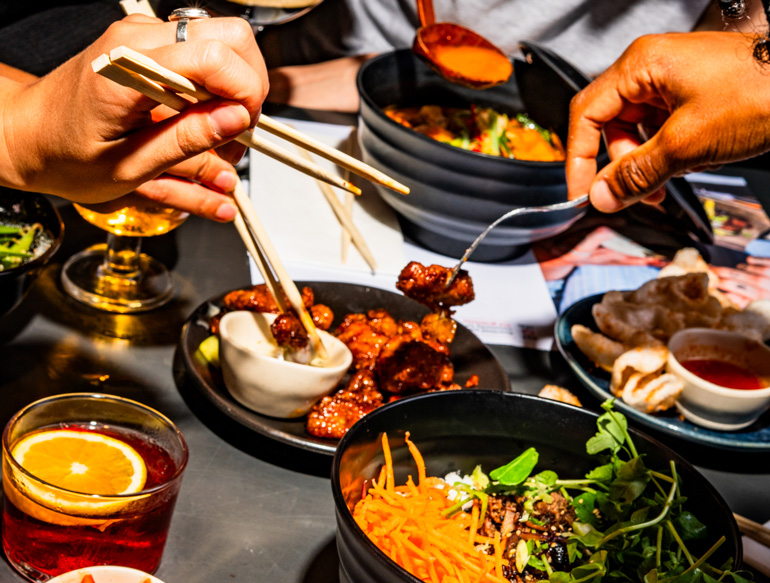 Communal eating, various dishes and drinks at Wagamama, Manchester