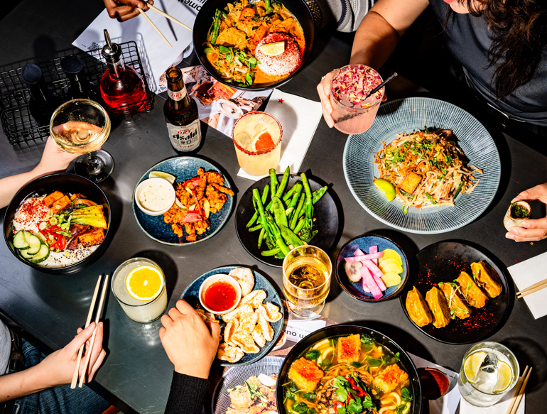 Communal eating, various dishes and drinks at Wagamama, Manchester