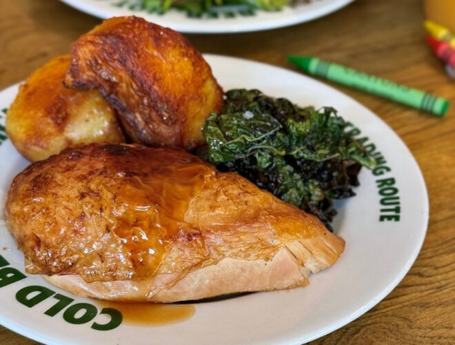 Chicken, kale and roast potatoes served at The Trading Route, with Crayola crayons scattered around the table.