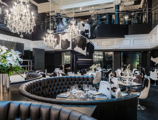 Black leather booth with table laid inside Gaucho Manchester.