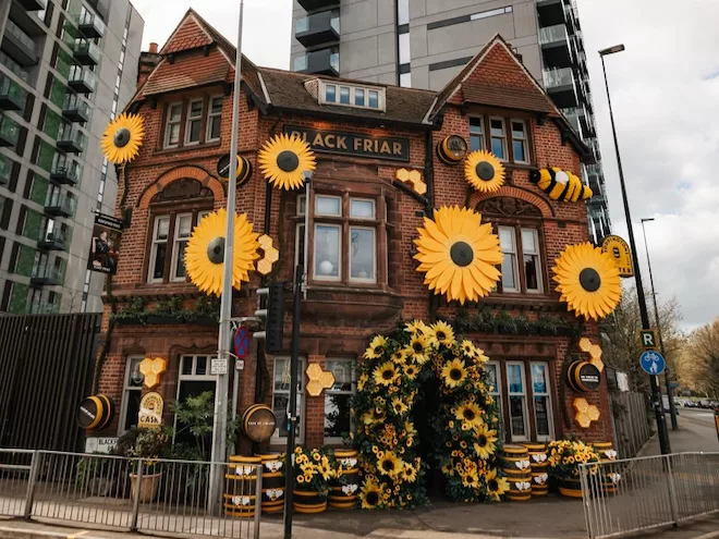 The Black Friar pub decorated with bees and sunflowers and barrels of Boddington's beer.
