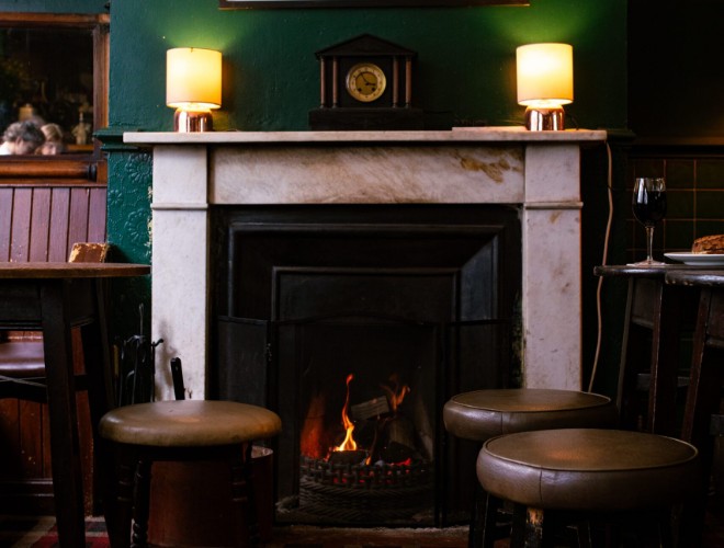 Open fire and traditional stools at The Angel