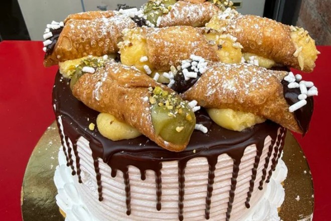 An impressive Italian celebration cake topped with cannoli from Sicilian NQ