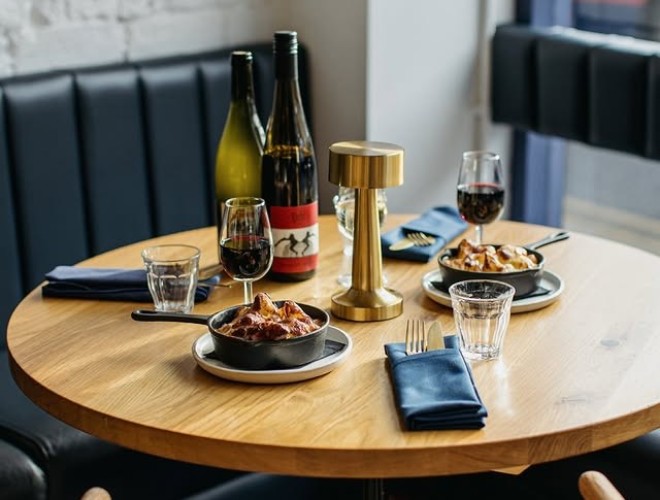 A table set for Sunday lunch at Belzan with two bottles of wine on the table and the sun shining through the window