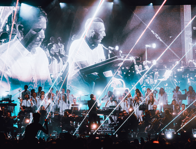 Lasers over a stage with a choir and an orchestra at an On The Waterfront concert in Liverpool.