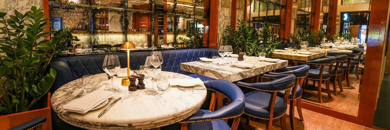 Interior of Cibo Gran Cafe in Wilmslow with blue leather banquettes and marble tables