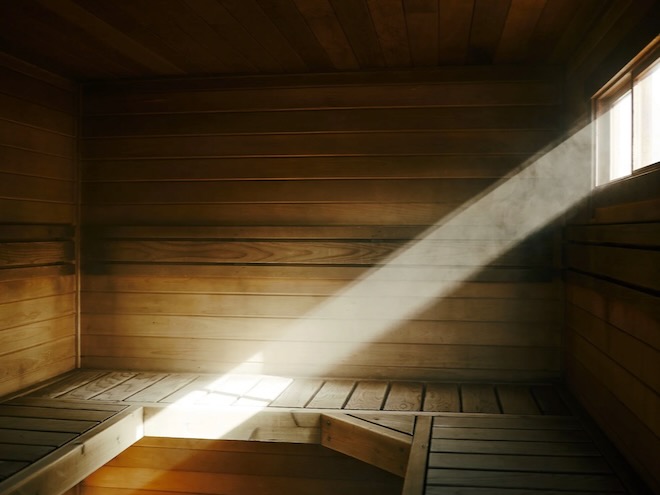 A beam of daylight hitting a bench in the sauna hut at The Good Sauna in Manchester.