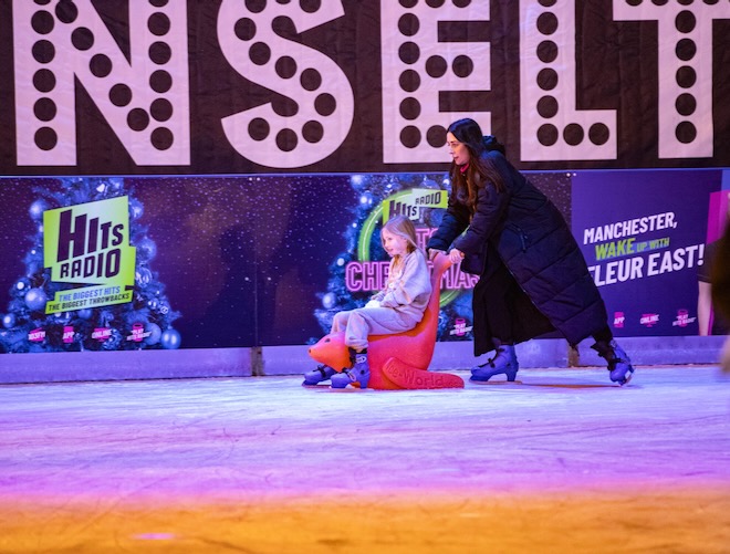 A lady pushing a child on a sleigh at the ice skating rink at The Trafford Centre.