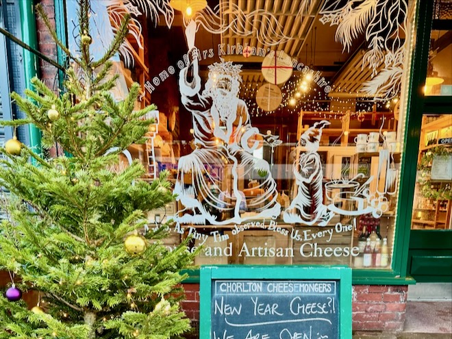 A Christmas tree outside a window decorated for Christmas at Chorlton Cheesemongers.