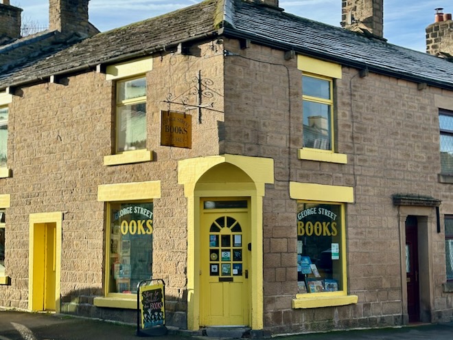 The yellow doors and window frames of George Street Community Bookshop in Glossop.