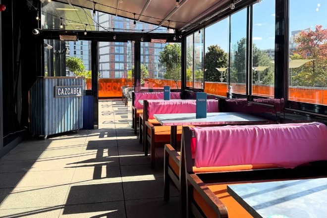 Banquette seating in pink and orange vinyl with Nell's balcony and views over Media City