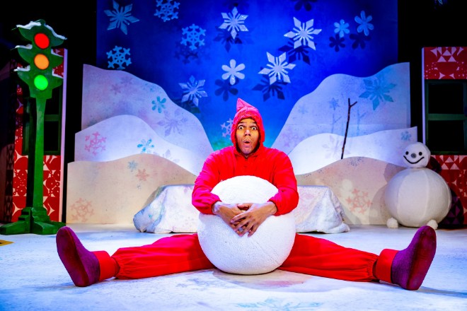 A performer from A Snowy Day holding a giant snowball