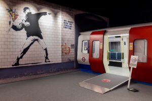 Recreation of London tube train with Banksy artwork on the wall.