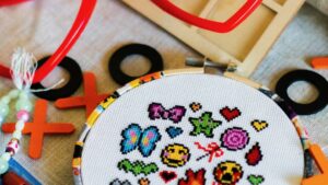 Cross stitch hoop with colourful pixelated icons and craft supplies
