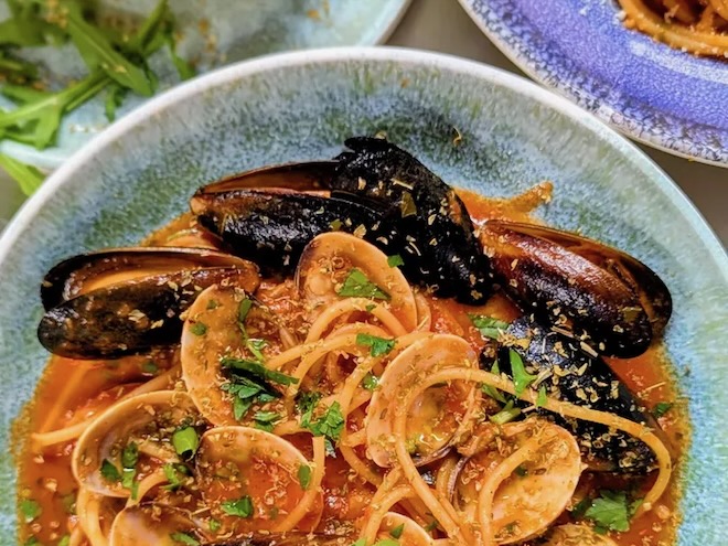 Spaghetti with mussels in a pale blue bowl at Sicilian NQ in Manchester.