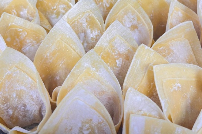 Endless rows of handmade wontons dusted with flour