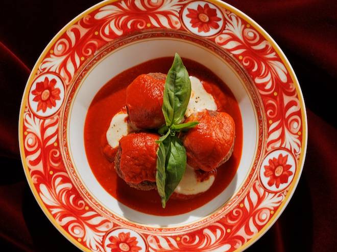 Meatballs in a red dish with red tomato sauce served at Louis in Manchester.