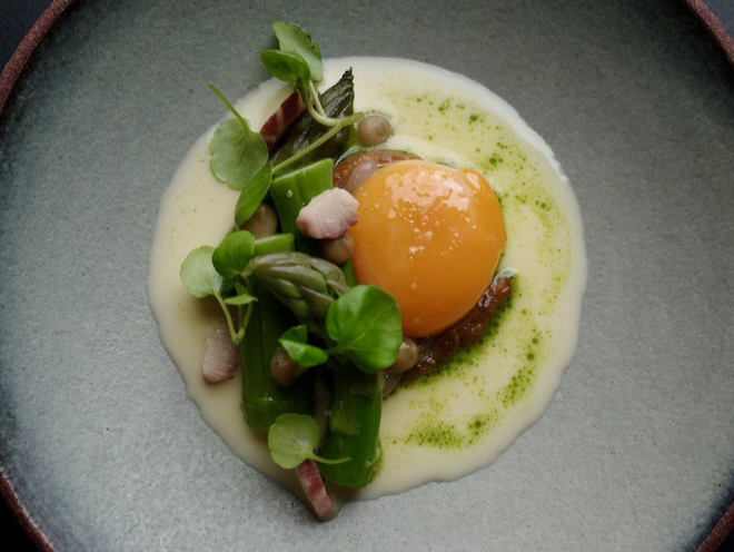 Maran yolk, asparagus, smoked eel, cod trimmings, and yoghurt whey served at Skof in Manchester