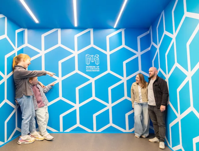 Two kids and their parents in an optical illusions room at The Museum of Illusions Manchester.