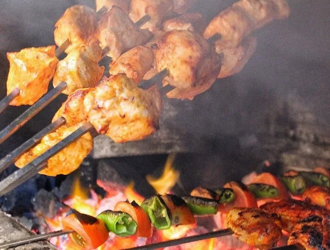 Prawn skewers and peppers on a charcoal grill
