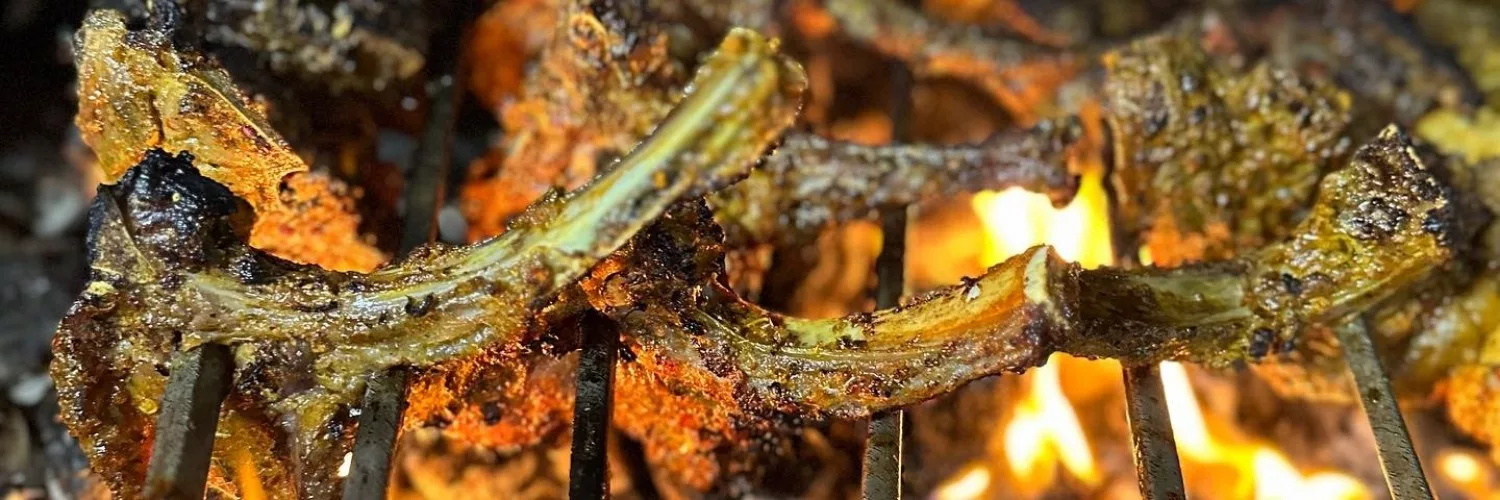Lamb chops being grilled over open flames